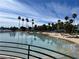Scenic view of the community, featuring sandy beach, a lake, and palm trees under a bright, clear sky at 3125 N Buffalo Dr # 1080, Las Vegas, NV 89128