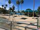 View of community featuring sandy beach, sunshades, and palm trees under a bright blue sky at 3125 N Buffalo Dr # 1080, Las Vegas, NV 89128