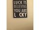 A rustic wooden sign on a neutral wall with the quote: LUCK is BELIEVING YOU ARE LUCKY at 3125 N Buffalo Dr # 1080, Las Vegas, NV 89128
