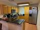 Well-lit kitchen with wooden cabinets, granite countertops, stainless steel appliances, and tile flooring at 3125 N Buffalo Dr # 1080, Las Vegas, NV 89128
