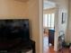 Living room featuring a tv, tan walls, and a glimpse into the bedroom at 3125 N Buffalo Dr # 1080, Las Vegas, NV 89128