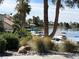 Lakefront home featuring boat dock with several boats on a clear lake surrounded by lush landscaping at 3125 N Buffalo Dr # 1080, Las Vegas, NV 89128