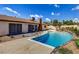 Backyard with a sparkling blue in-ground pool, desert landscaping and patio area at 3920 Autumn St, Las Vegas, NV 89120