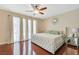 Serene bedroom featuring a tufted headboard, hardwood floors, and sheer curtains for soft natural light at 3920 Autumn St, Las Vegas, NV 89120