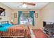 Bedroom featuring a ceiling fan, wood floors, and a large window with curtains at 3920 Autumn St, Las Vegas, NV 89120