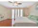 Bright bedroom with wood floors, a fan, a desk, and a large bed with an upholstered headboard at 3920 Autumn St, Las Vegas, NV 89120