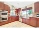 Gourmet kitchen with stainless steel appliances, a farmhouse sink, and rich wood cabinetry at 3920 Autumn St, Las Vegas, NV 89120