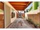 Charming covered patio featuring decorative flooring, lush plants, and access to an outdoor gated area at 3920 Autumn St, Las Vegas, NV 89120
