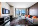 Modern living room with orange accent pillows and city views at 4381 W Flamingo Rd # 1212, Las Vegas, NV 89103
