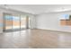 Spacious living room featuring neutral tile flooring, bright white walls, and large sliding glass doors to the backyard at 4510 E Brusca Way, Pahrump, NV 89061