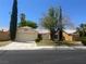 Inviting single-story home with a two car garage, desert landscaping, and mature trees in front yard at 4931 Crystal Breeze Ln, North Las Vegas, NV 89031