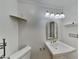 Bright bathroom with a pedestal sink, decorative mirror, and shelf at 5043 Spencer St # A, Las Vegas, NV 89119