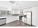 Updated kitchen boasts white cabinets, stainless steel appliances, and new gray backsplash, with hard surface countertops at 5120 Burnham Ave, Las Vegas, NV 89119