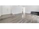 Bright living room with gray wood floors, white walls, and modern minimalist style at 5120 Burnham Ave, Las Vegas, NV 89119