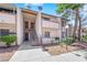 Inviting condo exterior features stairs to the second floor, neutral color palette and desert landscaping at 5241 Janfred Ct # 26, Las Vegas, NV 89103