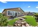 Landscaped backyard with a small water feature, green grass, patio, table and chairs at 5918 Peridot Falls Ave, Las Vegas, NV 89130