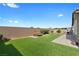 Lush backyard with green grass and a stone patio that is perfect for outdoor seating at 5918 Peridot Falls Ave, Las Vegas, NV 89130