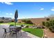 Spacious backyard with green grass, a table, chairs, string lights and water feature at 5918 Peridot Falls Ave, Las Vegas, NV 89130