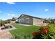 Home's backyard featuring synthetic grass and stone patio space under a cloud-filled blue sky at 5918 Peridot Falls Ave, Las Vegas, NV 89130