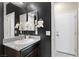 This bathroom boasts a granite countertop, a decorative mirror and towel rack, and dark walls at 5918 Peridot Falls Ave, Las Vegas, NV 89130