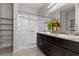 Well-lit bathroom featuring a double sink vanity with granite countertops and a tiled shower with glass doors at 5918 Peridot Falls Ave, Las Vegas, NV 89130