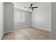 Sunny bedroom with wood-look flooring and a modern ceiling fan with window with blinds at 5918 Peridot Falls Ave, Las Vegas, NV 89130