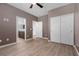 Modern bedroom with wood-look flooring, ensuite bath, and sliding door closet at 5918 Peridot Falls Ave, Las Vegas, NV 89130