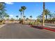 Gated community entrance with lush landscaping and palm trees under a clear blue sky at 5918 Peridot Falls Ave, Las Vegas, NV 89130