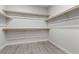 Spacious walk-in closet with wooden rods and shelves to maximize storage and organization at 5918 Peridot Falls Ave, Las Vegas, NV 89130