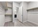 Walk-in closet with wooden rods and shelves leading to an open en-suite bathroom at 5918 Peridot Falls Ave, Las Vegas, NV 89130