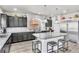 Modern kitchen featuring an island with seating, gray cabinetry, stainless steel appliances, and gray backsplash at 5976 Rockway Glen Ave, Las Vegas, NV 89141