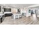 Large open kitchen with a granite countertop island, stainless steel appliances, and gray wood flooring at 5976 Rockway Glen Ave, Las Vegas, NV 89141