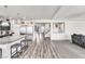 Open floor plan featuring kitchen with large island and stainless steel appliances flowing into the living room at 5976 Rockway Glen Ave, Las Vegas, NV 89141