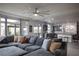 Open-concept living area with large windows, a modern fan, and a comfortable seating area at 5976 Rockway Glen Ave, Las Vegas, NV 89141