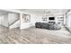A living room with a large, soft grey couch and a staircase is ready for entertaining at 5976 Rockway Glen Ave, Las Vegas, NV 89141
