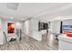 The loft features an orange couch, a black ottoman, grey floors, and a television at 5976 Rockway Glen Ave, Las Vegas, NV 89141
