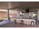 An outdoor bar with a built-in grill, television, hot tub, and an island with seating offers perfect entertaining space at 5976 Rockway Glen Ave, Las Vegas, NV 89141