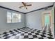Light-blue bedroom with checkered floor, ceiling fan, natural light, hallway view at 709 New Mexico St, Boulder City, NV 89005