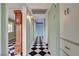 Hallway with checkered floors leads to a bedroom, featuring a cabinet and wall-mounted lighting at 709 New Mexico St, Boulder City, NV 89005