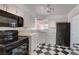 Well-lit kitchen with black appliances, white cabinets, and black and white flooring at 709 New Mexico St, Boulder City, NV 89005