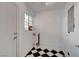 Utility area featuring black-and-white tile flooring, a window, and a white door at 709 New Mexico St, Boulder City, NV 89005