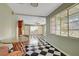 Bright living room with black-and-white tile, a ceiling fan, and large windows at 709 New Mexico St, Boulder City, NV 89005