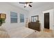 Bright bedroom with two windows, ceiling fan, dresser and closet, neutral colors and carpet at 712 Webber Park St, Henderson, NV 89011