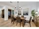 Dining room features a wooden table, stylish chandelier, and sliding glass doors for seamless indoor-outdoor living at 712 Webber Park St, Henderson, NV 89011