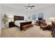 Spacious main bedroom with neutral tones, a dark wood bed frame and comfortable seating area at 712 Webber Park St, Henderson, NV 89011