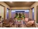 Charming covered patio featuring a brick floor, stone planter, and stylish outdoor furniture at 712 Webber Park St, Henderson, NV 89011