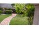 Inviting backyard with a stone path, green lawn, and manicured landscaping at 7313 Bosky Springs St, Las Vegas, NV 89131