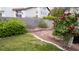 Landscaped backyard with brick planters, mature roses, and a lush green lawn at 7313 Bosky Springs St, Las Vegas, NV 89131