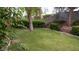 Spacious backyard with a green lawn, mature trees, and landscaped retaining walls at 7313 Bosky Springs St, Las Vegas, NV 89131