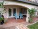 Covered patio with brick pavers, blue Adirondack chairs, and flowering plants at 7313 Bosky Springs St, Las Vegas, NV 89131